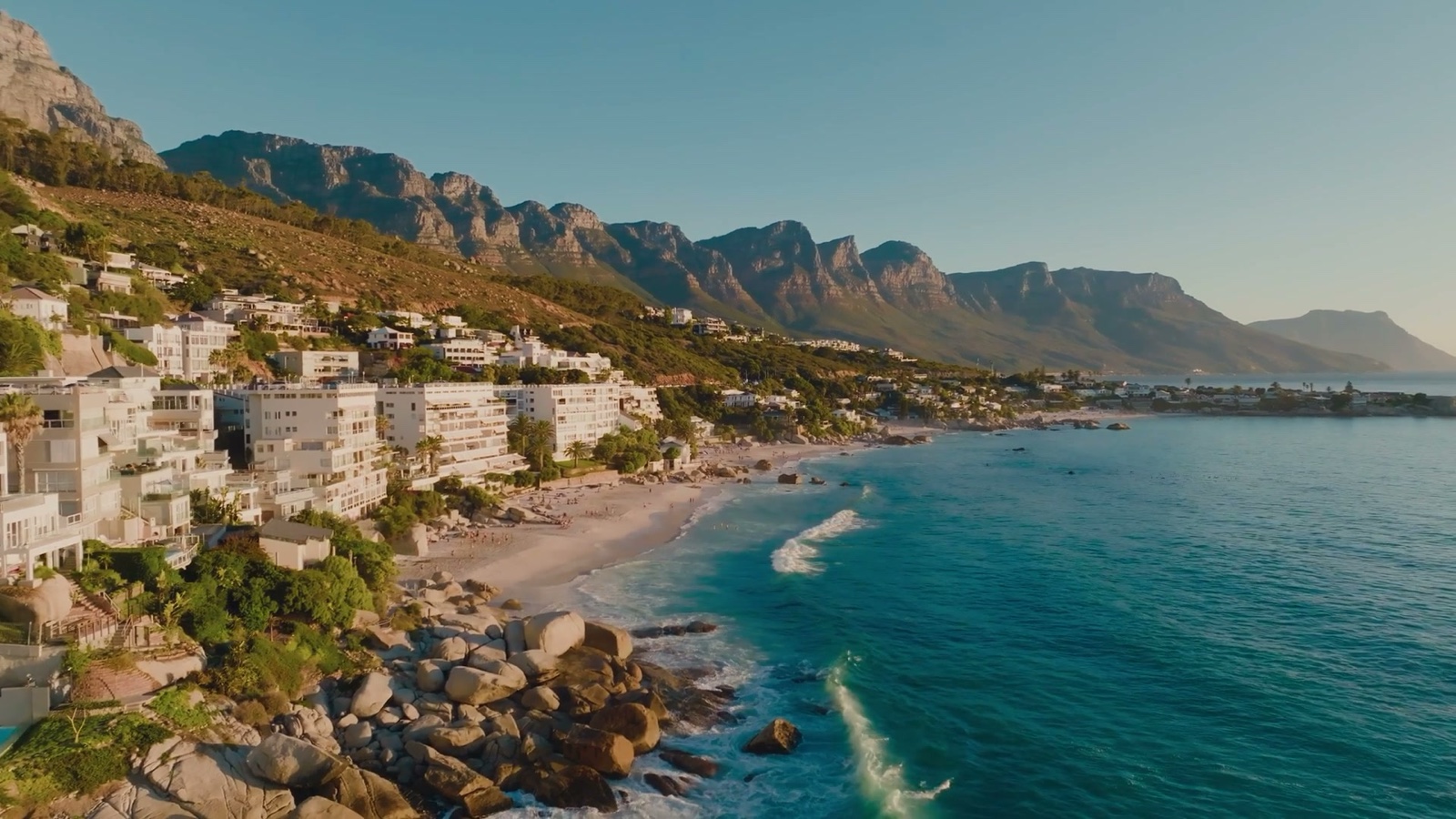 A wide establishing view of Clifton, the Twelve Apostles beyond